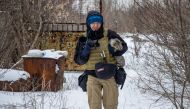Ukrainian photographer Maksim Levin carries a cat near the line of separation from Russian-backed separatists in Donetsk region, Ukraine January 25, 2022. Picture taken January 25, 2022. REUTERS/Stanislav Kozliuk