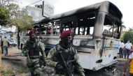 ri Lankan army commandos walk past a damaged bus after it was set on fire by demonstrators at the top of the road to Sri Lankan President Gotabaya Rajapaksa's residence during a protest against him, as many parts of the crisis-hit country face up to 13 hours without electricity due to a shortage of foreign currency to import fuel, in Colombo, Sri Lanka April 1, 2022. REUTERS/Dinuka Liyanawatte