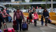 Ukrainians who fled to Mexico amid Russia's invasion of their homeland, walk with their belongings to cross the San Ysidro Land Port of Entry of the U.S.-Mexico border, in Tijuana, Mexico April 2, 2022. REUTERS/Jorge Duenes/File Photo


