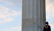 A person in graduation regalia stands on the Lincoln Memorial in Washington, D.C., U.S., May 14, 2021. REUTERS/Andrew Kelly/File Photo

