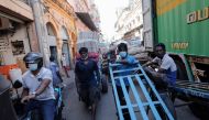 Men wait with their carts at a market, amid the country's economic crisis in Colombo, Sri Lanka, April 7, 2022. REUTERS/Dinuka Liyanawatte