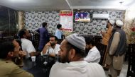 People watch the speech of Pakistani Prime Minister Imran Khan on a television screen, at a cafe in Islamabad, Pakistan, April 8, 2022. Reuters/Akhtar Soomro
 