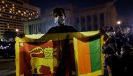 A boy holds a Sri Lankan national flag in front of the Presidential Secretariat during a protest against Sri Lankan President Gotabaya Rajapaksa, amid the country's economic crisis, in Colombo, Sri Lanka, April 10, 2022. REUTERS/Dinuka Liyanawatte