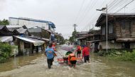 Rescuers push a woman in a raft on a flooded road, after the tropical storm Megi hit, in Leyte Province, Philippines April 10, 2022. Picture taken April 10, 2022. Philippine Coast Guard/Handout via REUTERS 