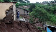 A woman stands at her front door after heavy rains caused flood damage in KwaNdengezi, Durban, South Africa, April 12, 2022. REUTERS/Rogan Ward