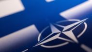 Finnish and NATO flags are seen printed on paper this illustration. Reuters/Dado Ruvic/Illustration