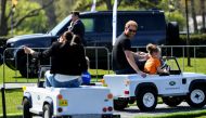 Britain's Prince Harry and Meghan, Duchess of Sussex, ride mini Land Rover model vehicles with children as they attend the Land Rover Driving Challenge of the Invictus Games in The Hague, Netherlands April 16, 2022. REUTERS/Piroschka Van De Wouw
