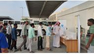 Workers receiving Iftar meals provided by the Ministry of Municipality in coordination with Afif Charity.