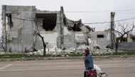 A local resident walks past a building destroyed during Ukraine-Russia conflict in the southern port city of Mariupol, Ukraine April 19, 2022. REUTERS/Alexander Ermochenko