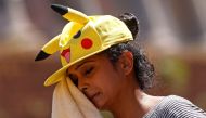 A woman wipes off sweat with a towel near the Colosseum during a heatwave across Italy, in Rome, August 12, 2021. REUTERS/Guglielmo Mangiapane/File Photo