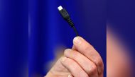 Bridget Cosgrave, Director General of DigitalEurope, displays a harmonised mobile phone charger during a news conference at the European Commission headquarters in Brussels February 8, 2011. REUTERS/Francois Lenoir/File Photo