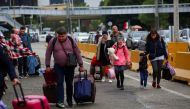 Ukrainians who fled to Mexico amid Russia's invasion of their homeland, walk with their belongings to cross the San Ysidro Land Port of Entry of the U.S.-Mexico border, in Tijuana, Mexico April 2, 2022. REUTERS/Jorge Duenes/File Photo


