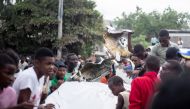 People gather around the wreckage of a small plane that crashed onto a busy street, killing multiple people including the pilot, in Port-au-Prince, Haiti, April 20, 2022. Picture taken April 20, 2022. REUTERS/Lutherson Leon