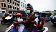 A man drives his scooter as he passes by a protest demanding justice for K.D. Chaminda Lakshan, 41, who died after getting caught up in a clash as he went to the petrol station at Rambukkana to fill his motorcycle on Tuesday amid the country's ongoing economic crisis, in Colombo, Sri Lanka, April 22, 2022. REUTERS/Navesh Chitrakar