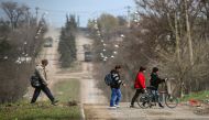 People cross a road in the course of Ukraine-Russia conflict in the southern port city of Mariupol, Ukraine April 21, 2022. REUTERS/Chingis Kondarov/File Photo