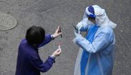 A worker in a protective suit checks QR code on the phone of a resident for nucleic acid testing during lockdown, amid the coronavirus disease (COVID-19) pandemic, in Shanghai, China, April 26, 2022. Reuters/Aly Song