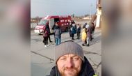 Mykhailo Puryshev poses for a selfie photo in front of a car as he evacuates people fleeing Russia's invasion of Ukraine, in Zaporizhzhia, Ukraine, in this undated handout photo obtained by Reuters on April 26, 2022. Courtesy of Mykhailo Puryshev/Handout via REUTERS