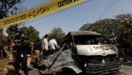 Police officers and a crime scene unit gather near a passenger van, after a blast at the entrance of the Confucius Institute University of Karachi, Pakistan April 26, 2022. Reuters /Akhtar Soomro