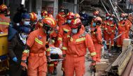 Rescue workers carry an injured person on a stretcher at a site where a building collapsed in Changsha, Hunan province, China May 1, 2022. China Daily/via REUTERS