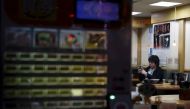 A customer looks at his mobile phone at Soba noodle restaurant at a shopping district in Tokyo, Japan, February 25, 2016. REUTERS/Yuya Shino/Files

