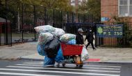 A man with a protective face mask walks with recyclables in a shopping cart as the spread of coronavirus disease (COVID-19) continues in the borough of Brooklyn in New York, U.S., October 13, 2020. REUTERS/Shannon Stapleton/File Photo

