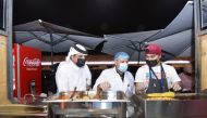 Municipal officials inspecting a food kiosk during the Eid Festival at Doha Corniche. 