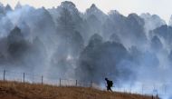 A firefighter works to combat the Hermits Peak and Calf Canyon wildfire, near Las Vegas, New Mexico, U.S. May 4, 2022. Picture taken May 4, 2022. REUTERS/Kevin Mohatt
