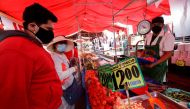 FILE PHOTO: Customers buy tomatoes at a street market, in Mexico City, Mexico December 17, 2021. REUTERS/Luis Cortes/File Photo
