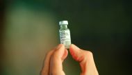 A healthcare worker holds a vial of the AstraZeneca vaccine during a ceremony to announce the AstraZeneca vaccine being produced in the country by Fiocruz Institute, in Brasilia, Brazil February 22, 2022. REUTERS/Adriano Machado/File Photo