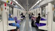 A passenger in a protective suit rides on a subway train on the first day of parts of city's subway services resumed in Shanghai, China May 22, 2022. Reuters/Brenda Goh
