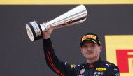 First placed Max Verstappen of Red Bull celebrates with his trophy on the podium after the race REUTERS/Albert Gea
