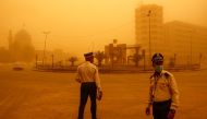 Traffic police officers direct vehicles during a sandstorm in Baghdad, Iraq, May 23, 2022. REUTERS/Thaier Al-Sudani
