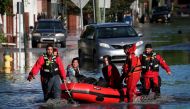 FILE PHOTO: First responders pull local residents in a boat as they perform rescues of people trapped by floodwaters after the remnants of Tropical Storm Ida brought drenching rain, flash floods and tornadoes to parts of the northeast in Mamaroneck, New York, U.S., September 2, 2021. REUTERS/Mike Segar/File Photo
