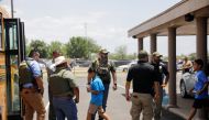 Children get on a school bus as law enforcement personnel guard the scene of a suspected shooting near Robb Elementary School in Uvalde, Texas, U.S. May 24, 2022. REUTERS/Marco Bello
