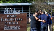 People gather at Robb Elementary School, the scene of a mass shooting in Uvalde, Texas, U.S., May 25, 2022. REUTERS/Nuri Vallbona 