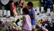Children pay their respects in front of the memorial at Robb Elementary school, where a gunman killed 19 children and two adults, in Uvalde, Texas, U.S. May 28, 2022. REUTERS/Marco Bello
