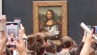 Visitors take pictures and video of the painting 