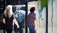 People walk past a damaged store window at a crime scene after a deadly mass shooting on South Street in Philadelphia, Pennsylvania, U.S., June 5, 2022. REUTERS/Bastiaan Slabbers



