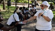 TK West, a volunteer with Dominion Tabernacle Ministries, gives out cold water bottles during a heatwave with expected temperatures of 102 F (39 C) in Dallas, Texas, U.S. June 12, 2022. The ministry brought water and clothes to houseless people in Dallas to help them bear the high temperatures. REUTERS/Shelby Tauber

