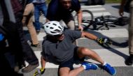 U.S. President Joe Biden falls to the ground after riding up to members of the public during a bike ride in Rehoboth Beach, Delaware, U.S., June 18, 2022. REUTERS/Elizabeth Frantz
