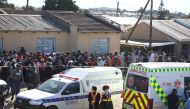 Crowd gathers as forensic personnel investigate after the deaths of patrons found inside the Enyobeni Tavern, in Scenery Park, outside East London in the Eastern Cape province, South Africa, June 26, 2022. (Reuters)