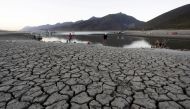 People gather along the dried basin of the La Boca dam as more than half of Mexico faces moderate to severe drought conditions, in Santiago, Mexico. (Reuters/Daniel Becerril/File Photo)