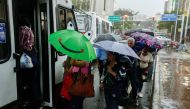 People in a line to board a bus use umbrellas to cover from the rain caused by Potential Tropical Cyclone Two, which the U.S. National Hurricane Center says will likely develop into tropical storm Bonnie, as it passes through the Caribbean, in Caracas, Venezuela June 29, 2022. REUTERS/Leonardo Fernandez Viloria