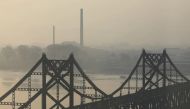 Buildings in North Korea's Sinuiju are seen behind the Friendship Bridge over the Yalu river, during sunrise in Dandong, Liaoning province, China April 20, 2021. REUTERS/Tingshu Wang

