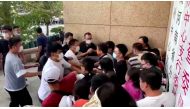 Plain-clothed security personnel scuffle with demonstrators during a protest over the freezing of deposits by some rural-based banks, outside a People's Bank of China building in Zhengzhou, Henan province, China July 10, 2022, in this screengrab from video obtained by REUTERS