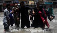 A family wades through a flooded street during the monsoon season, in Karachi, Pakistan, on July 11, 2022. (REUTERS/Akhtar Soomro)

