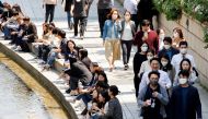 People wear masks to prevent the spread of the coronavirus disease (COVID-19) as they take a walk on a sunny spring day in Seoul, South Korea, May 3, 2022. REUTERS/ Heo Ran/File Photo
