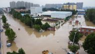 An aerial view shows rescue workers evacuating residents on a flooded road following heavy rainfall in Zhengzhou, Henan province, China July 22, 2021. Picture taken with a drone. REUTERS/Aly Song/File Photo