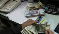 A currency exchange trader counts money at his office in Islamabad November 26, 2012. REUTERS/Faisal Mahmood/Files