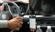 A driver of Chinese ride-hailing service Didi drives with a phone showing a navigation map on Didi's app, in Beijing, China July 5, 2021. REUTERS/Tingshu Wang

